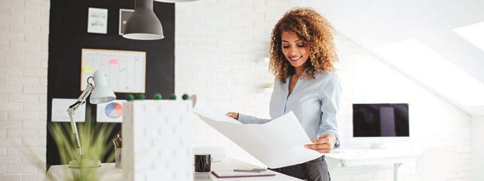 Woman looking at a business plan with a shopping bag in front of her
