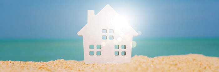 White poster board house on a beach background.