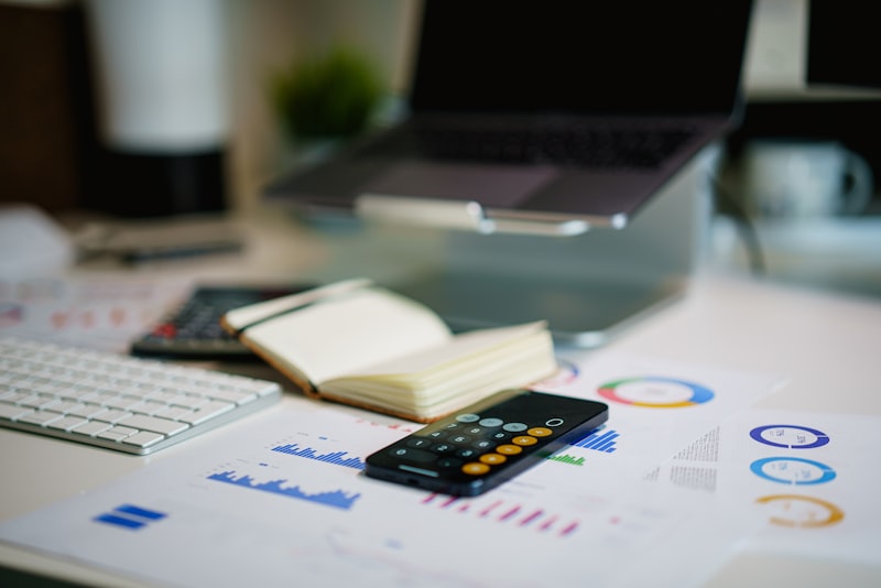 Office desk with a smartphone and printed financial charts