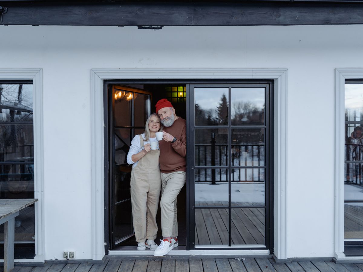 A senior couple sitting together with coffee on their porch